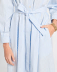 Light blue and white striped dress with a tie waist on a plain background