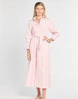 Woman wearing a pink dress with a belt on a white background