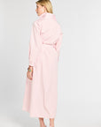 Woman wearing a light pink dress against a white background