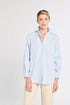 Woman wearing a light blue striped shirt against a white background