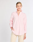 Woman wearing a light pink striped shirt and beige pants on a white background
