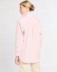 Woman wearing a light pink blouse with a white background