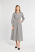 Woman wearing a gray and white striped dress on a white background
