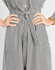 Black and white striped dress with a tie waist on a plain background
