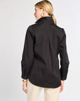 Woman wearing a black jacket on a light gray background