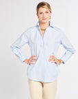 Woman wearing a light blue striped shirt and beige pants on a white background