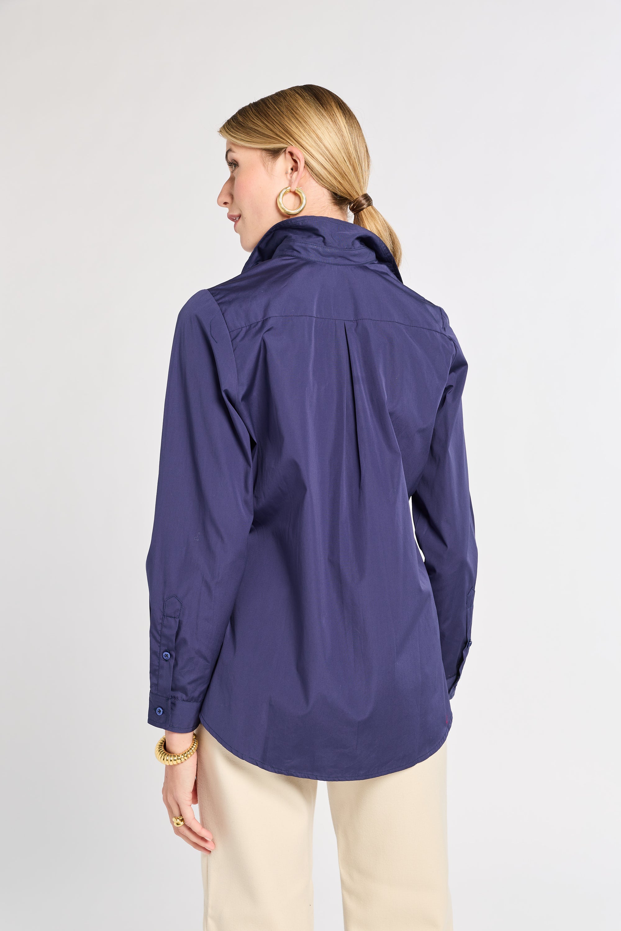 Woman wearing a navy shirt on a plain background