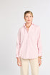 Woman wearing a pink striped shirt and beige pants on a white background