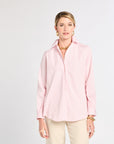 Woman wearing a pink striped shirt and beige pants on a white background
