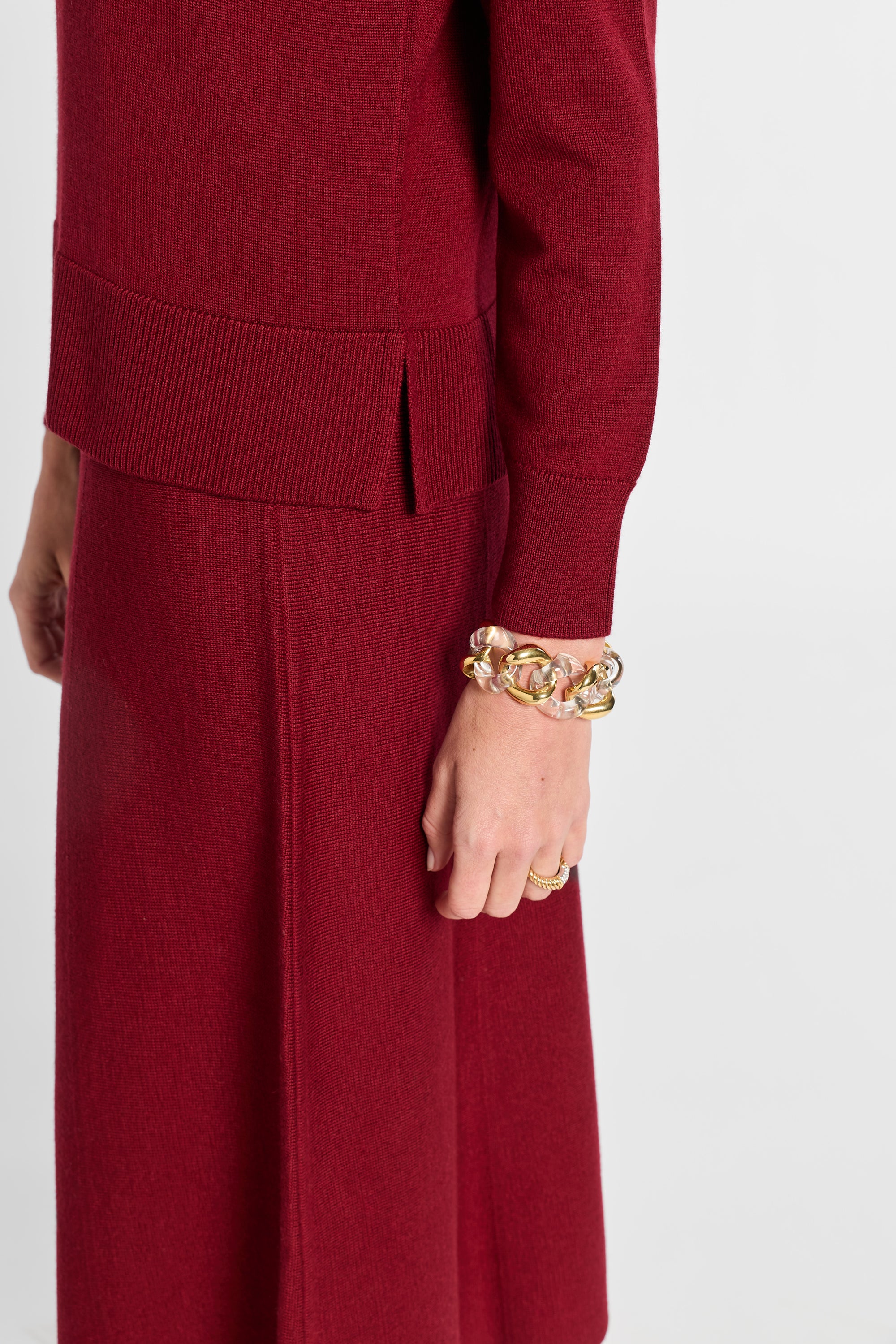Red outfit with a gold bracelet on a white background