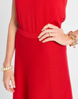 Red dress with a focus on the waist area, worn by a person with bracelets and a ring.