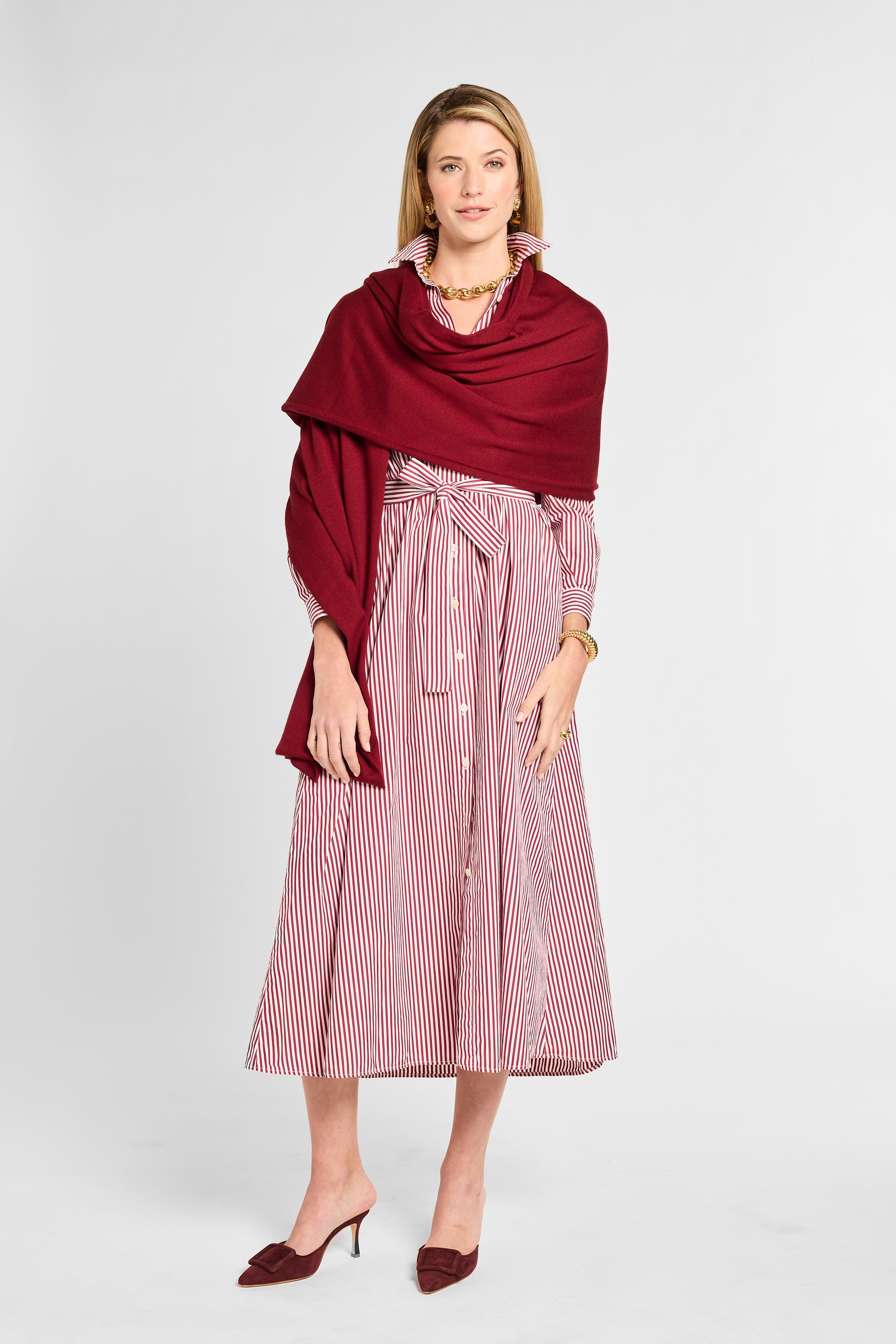 Woman wearing a red and white striped dress with a red shawl on a white background