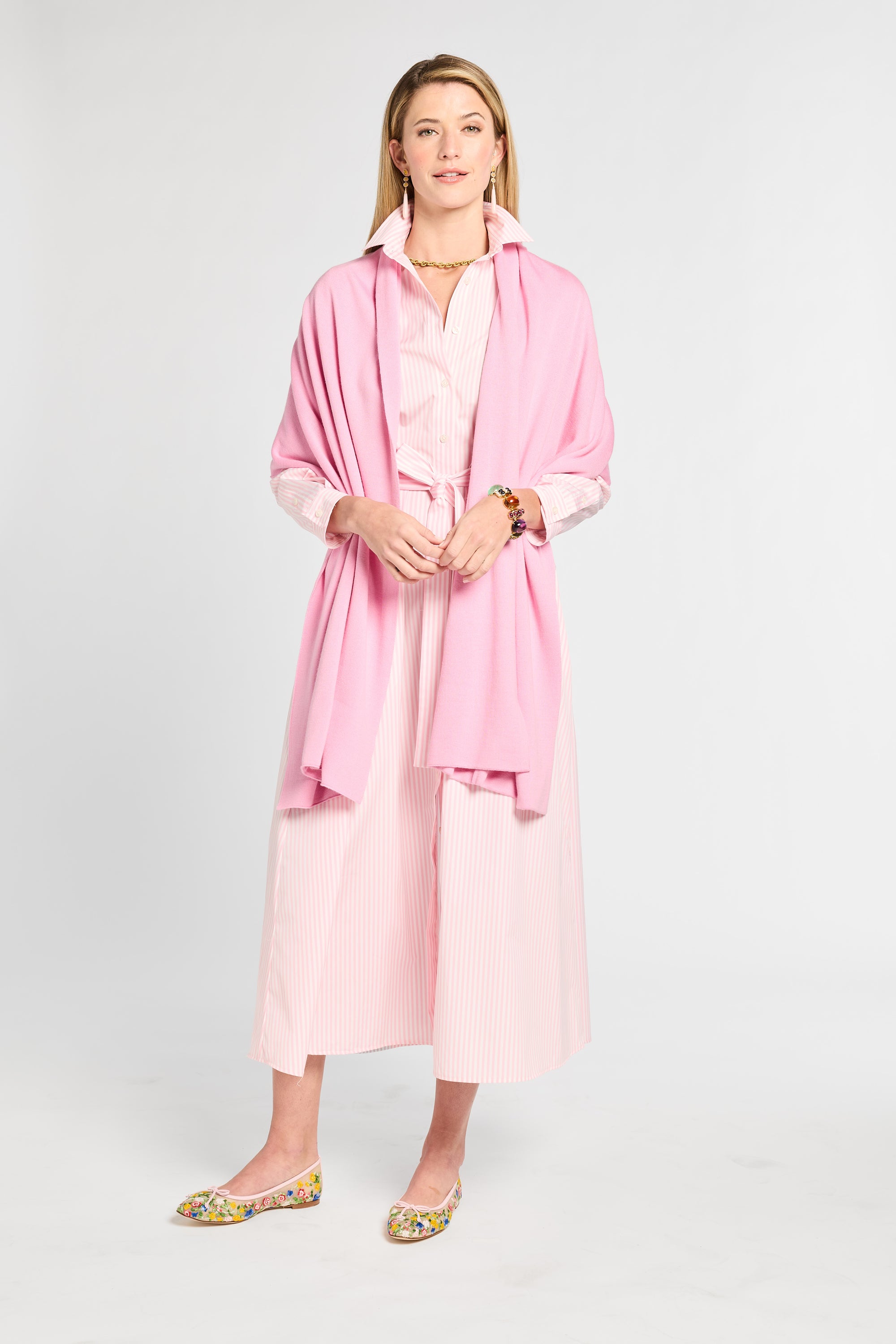 Woman wearing a pink outfit with a light gray background