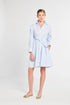 Woman wearing a light blue dress with a white background