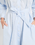Light blue and white striped dress with a belt on a plain background