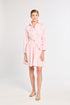 Woman wearing a pink dress with a belt on a white background