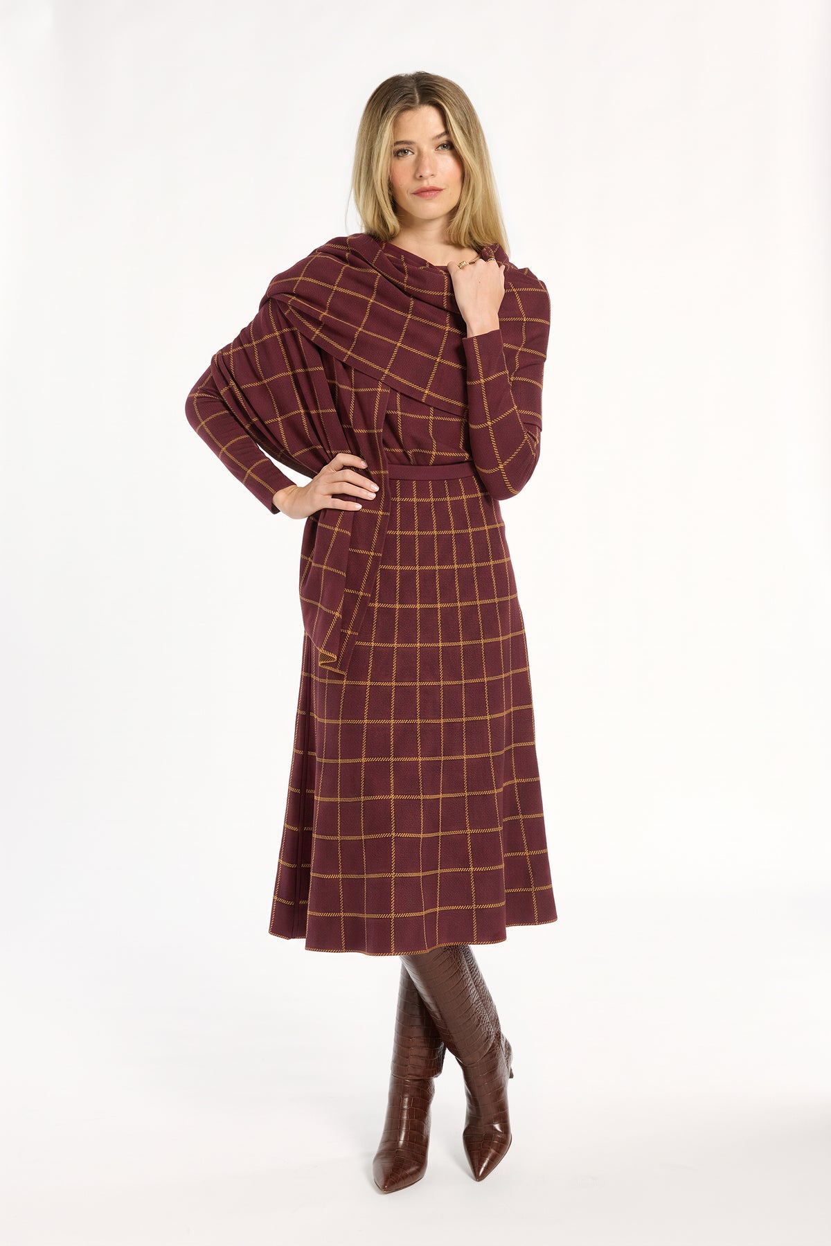 woman wearing a plaid skirt and wrap set with tall croc boots on a white background