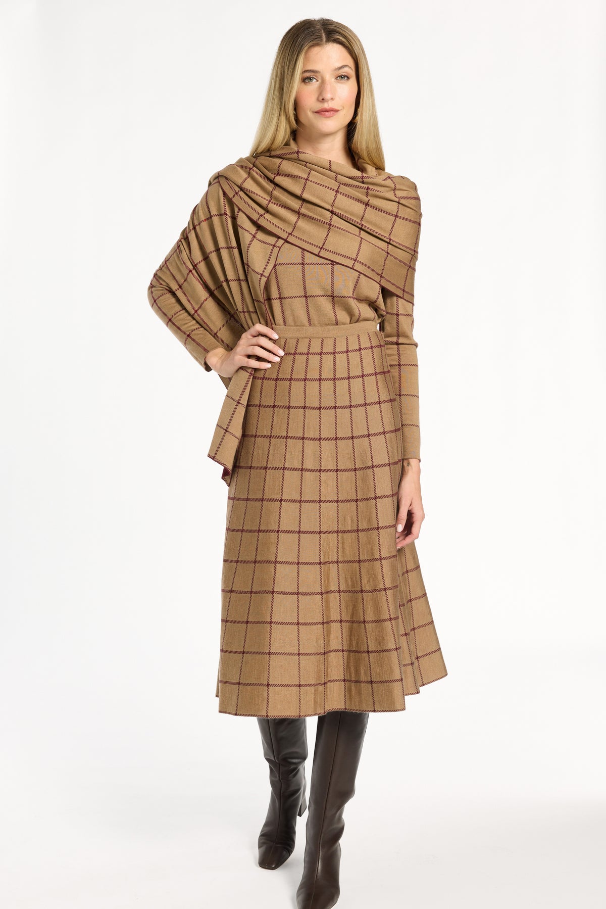 A woman modeling the camel side of the Windowpane Plaid Reversible Flared Skirt with the matching crewneck and brown boots, back view, photographed against a plain white studio background.