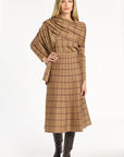 A woman modeling the camel side of the Windowpane Plaid Reversible Flared Skirt with the matching crewneck and brown boots, back view, photographed against a plain white studio background.