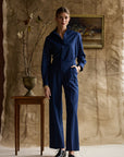 Woman modeling navy striped pants on a tan background