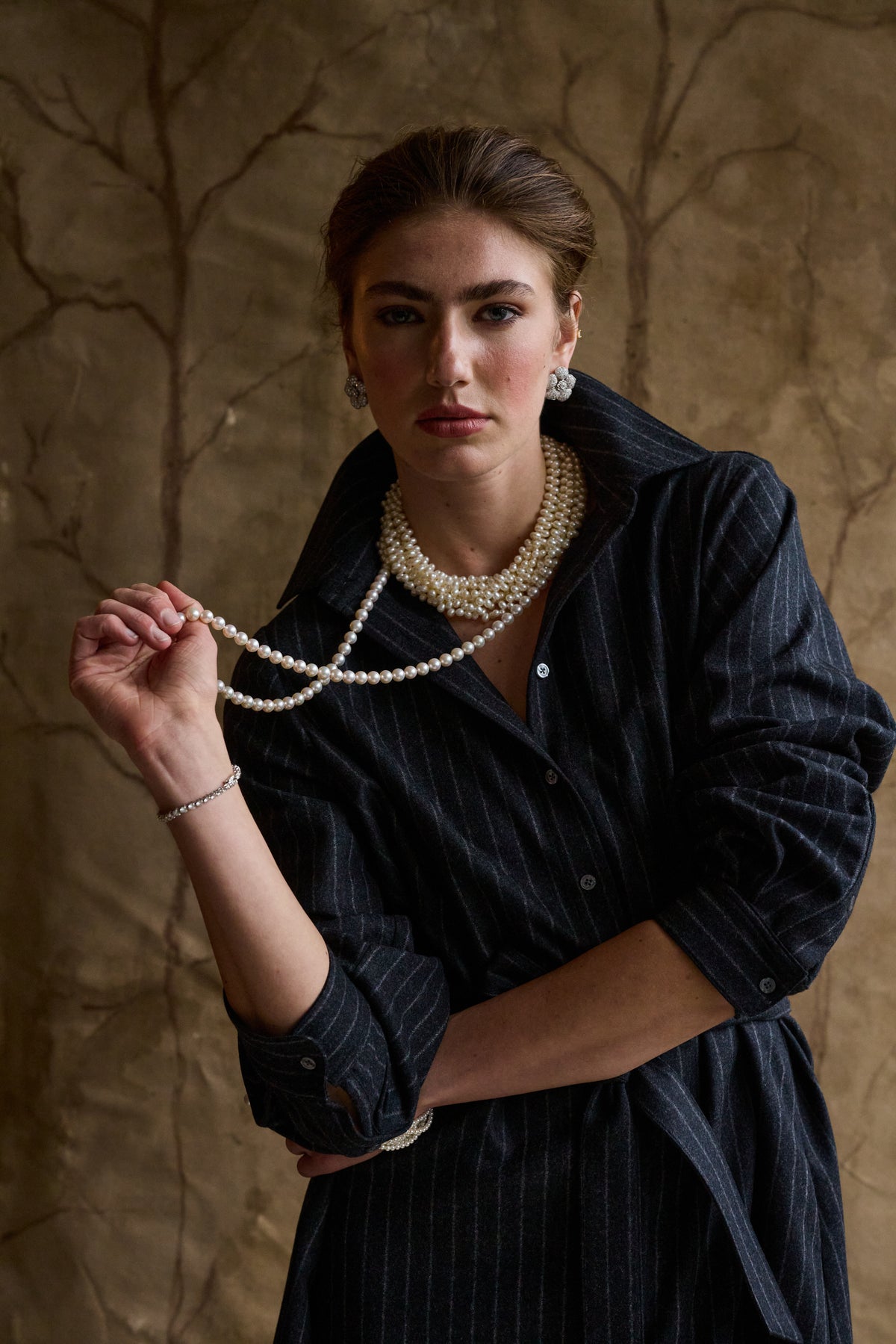 Woman modeling a stripe charcoal dress on a tan background