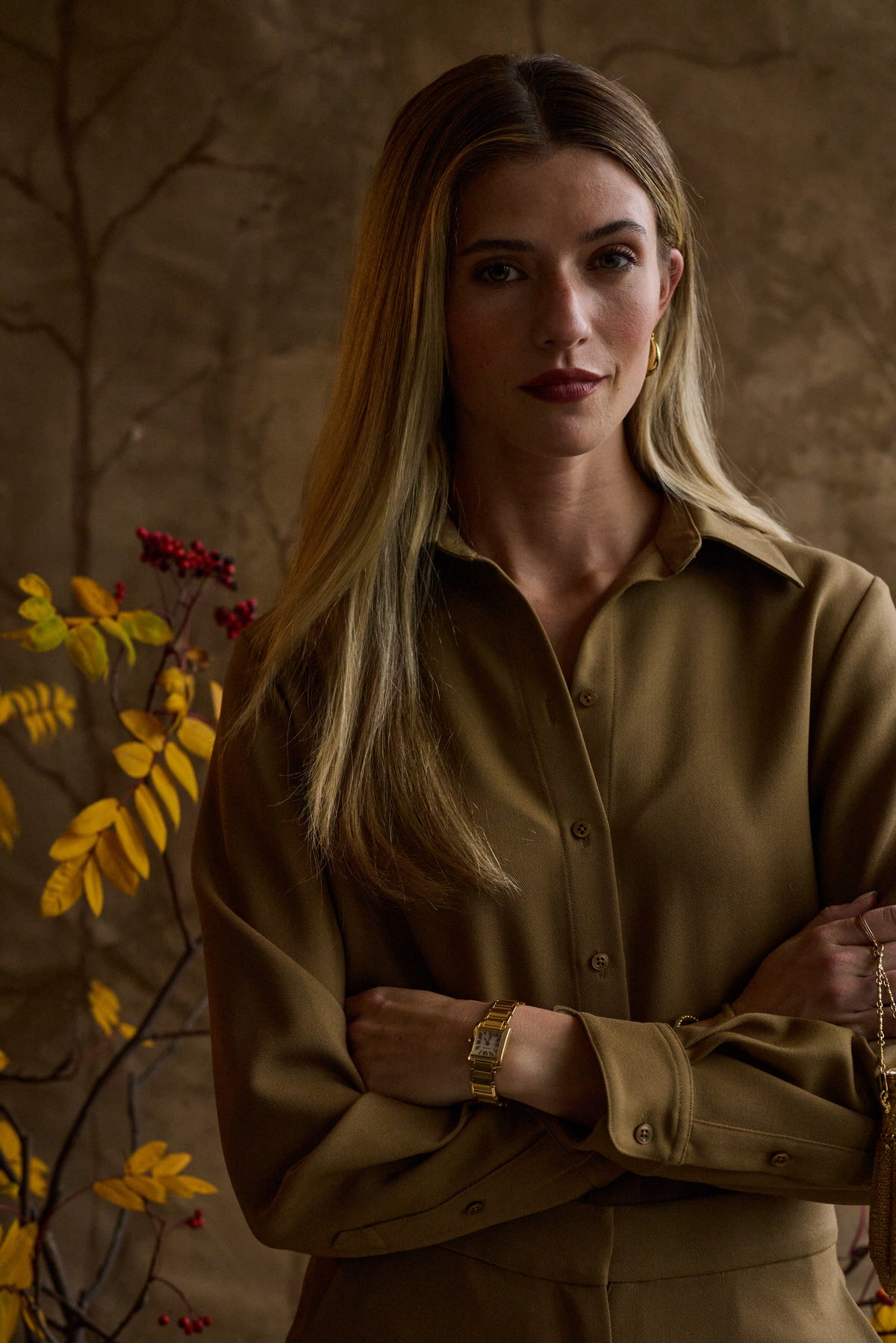 Woman modeling a green blouse with a tan background
