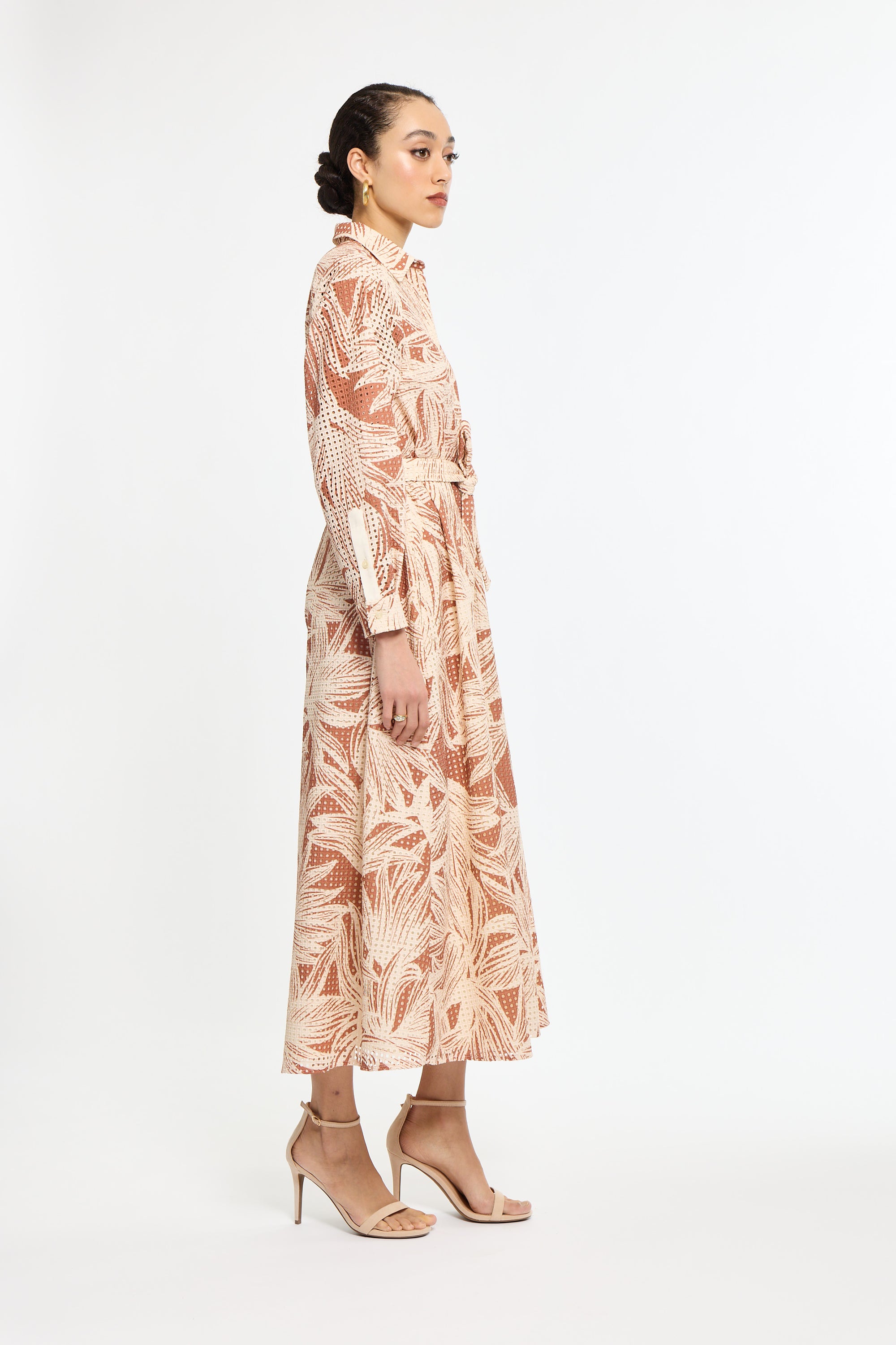 Woman wearing a long, patterned dress on a white background