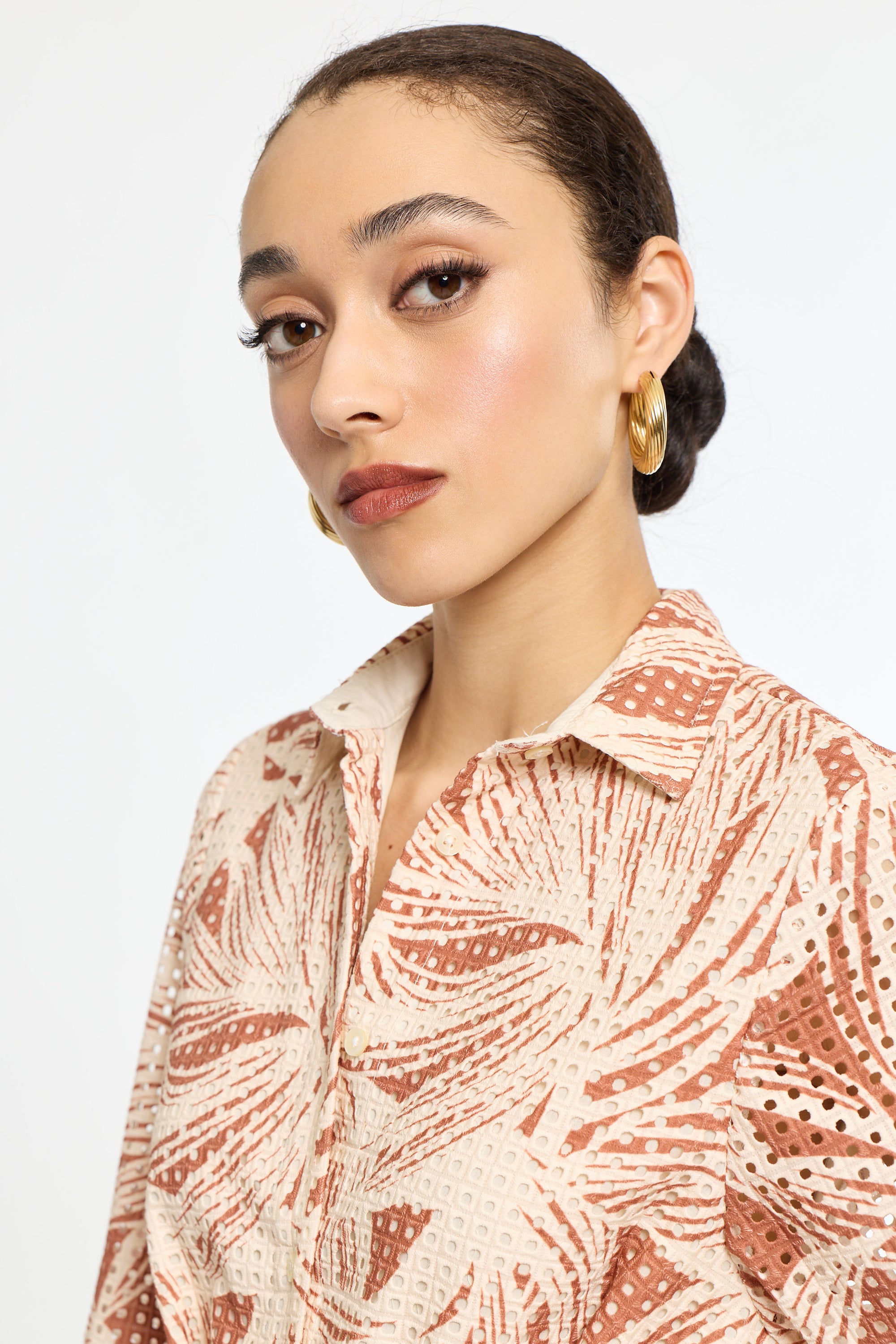 Woman wearing a patterned shirt against a plain background