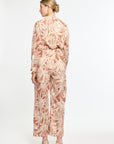Woman wearing a patterned outfit on a white background