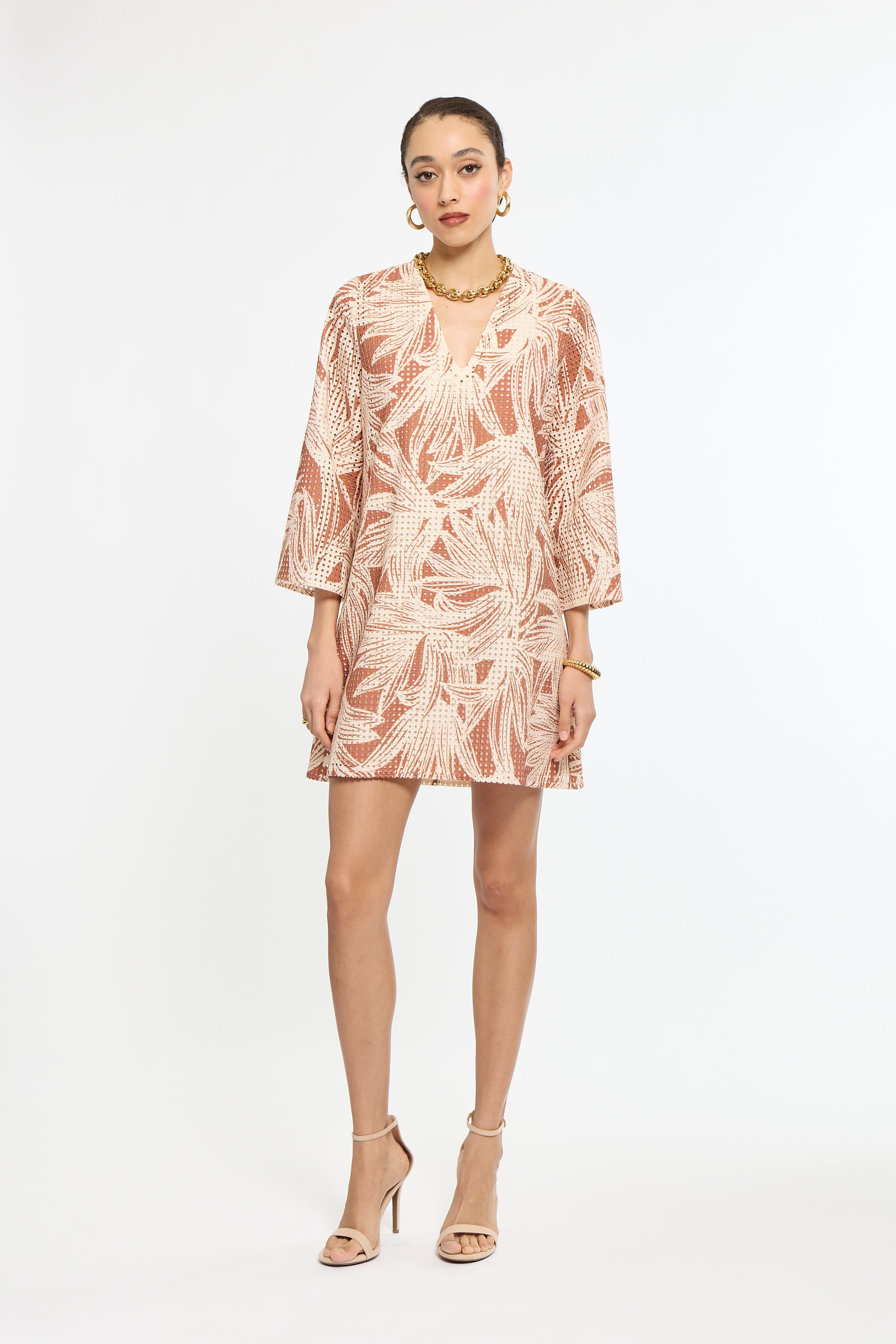 Woman wearing a patterned dress on a white background