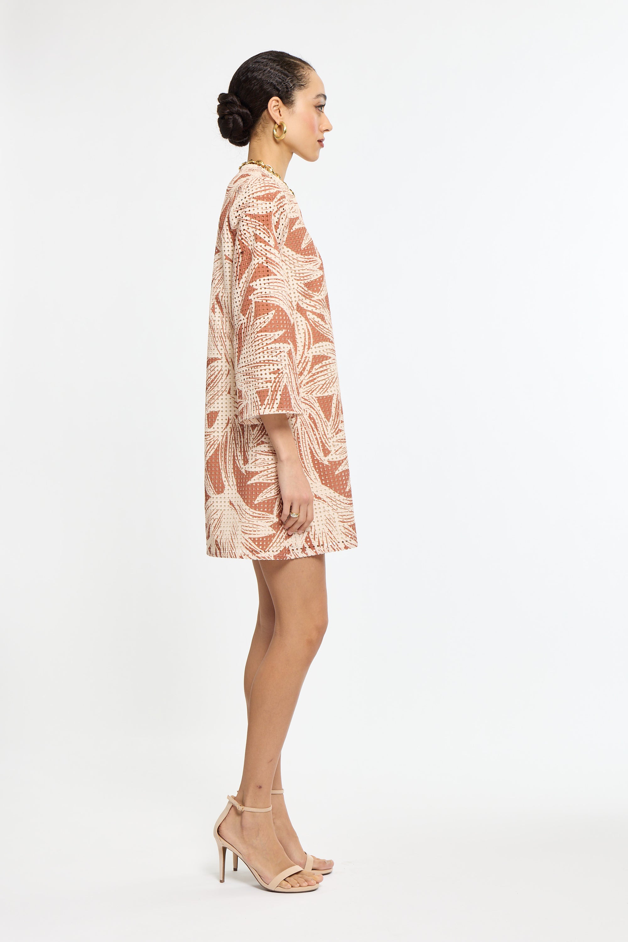 Woman wearing a patterned dress on a white background