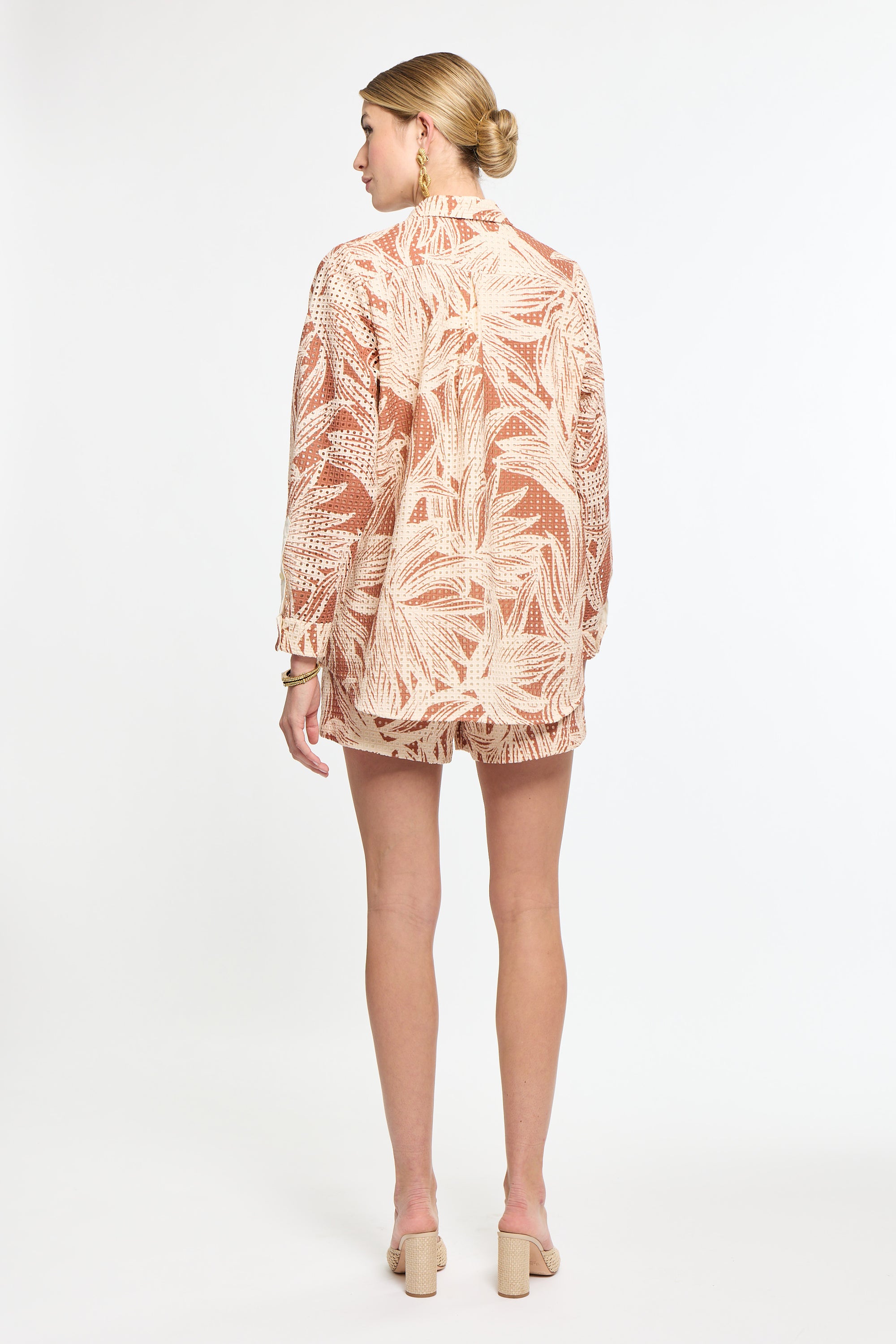 Woman wearing a patterned outfit on a white background