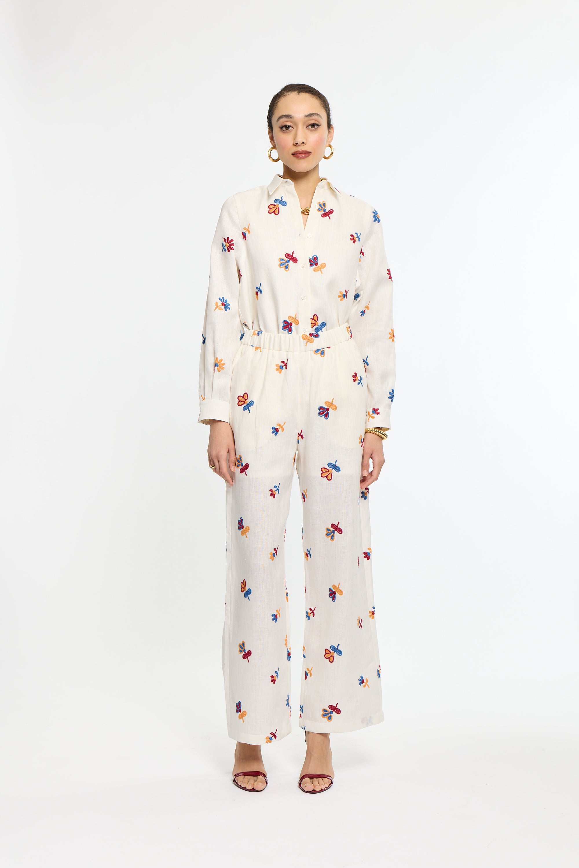 Woman wearing a white floral pajama set on a white background