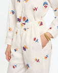 White outfit with colorful floral embroidery on a white background