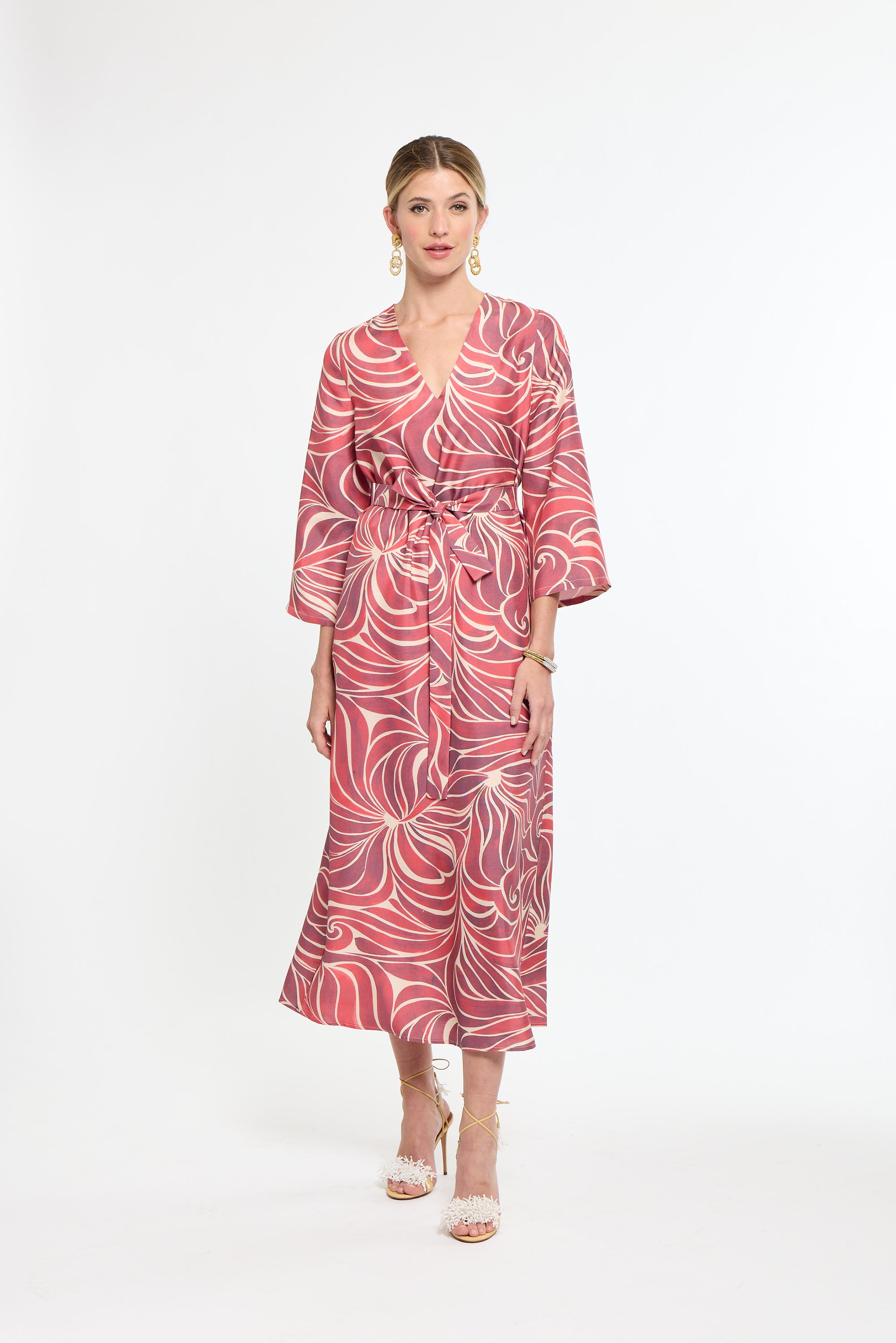 Woman wearing a red and white patterned dress on a white background