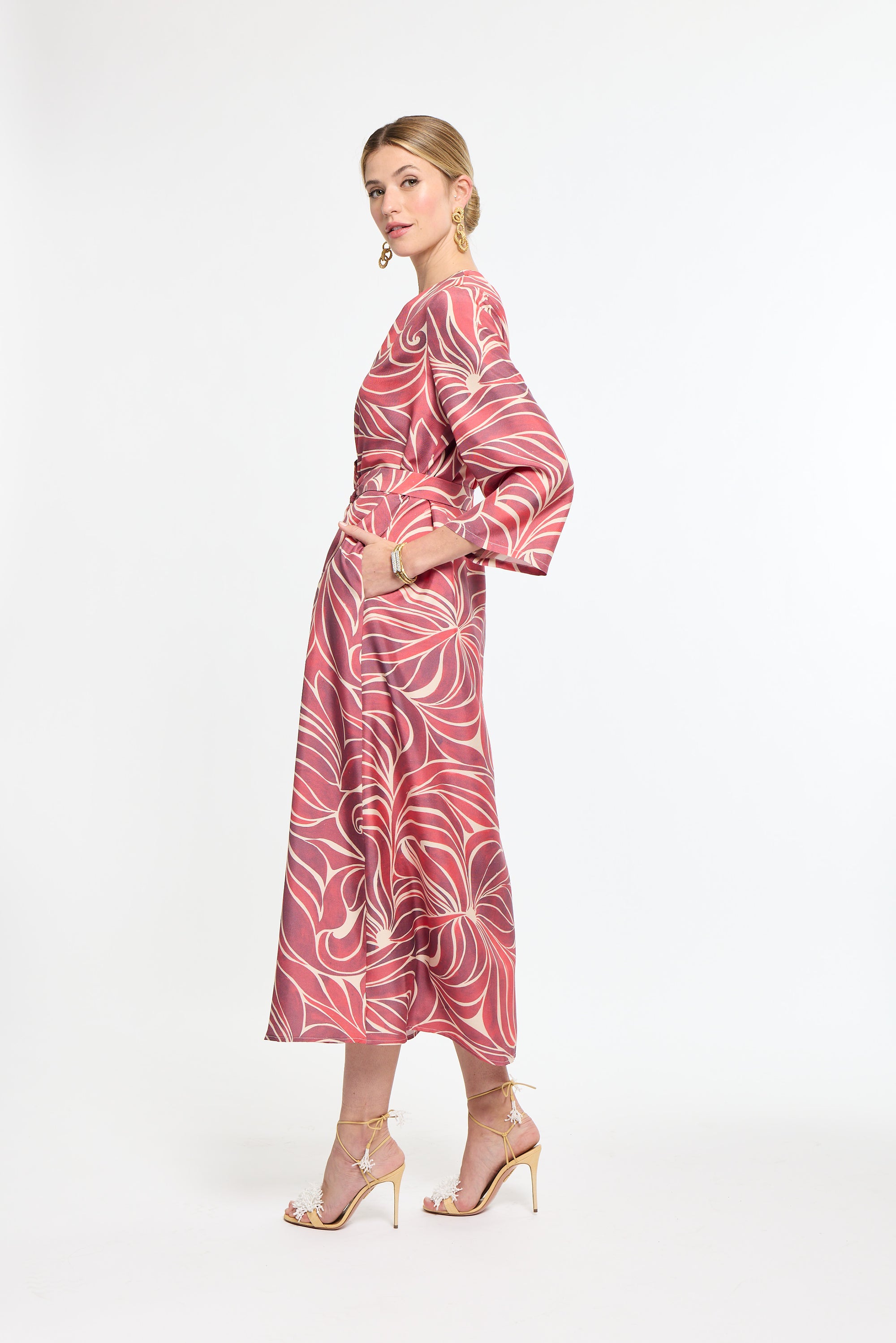 Woman wearing a pink patterned dress on a white background
