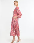 Woman wearing a pink patterned dress on a white background