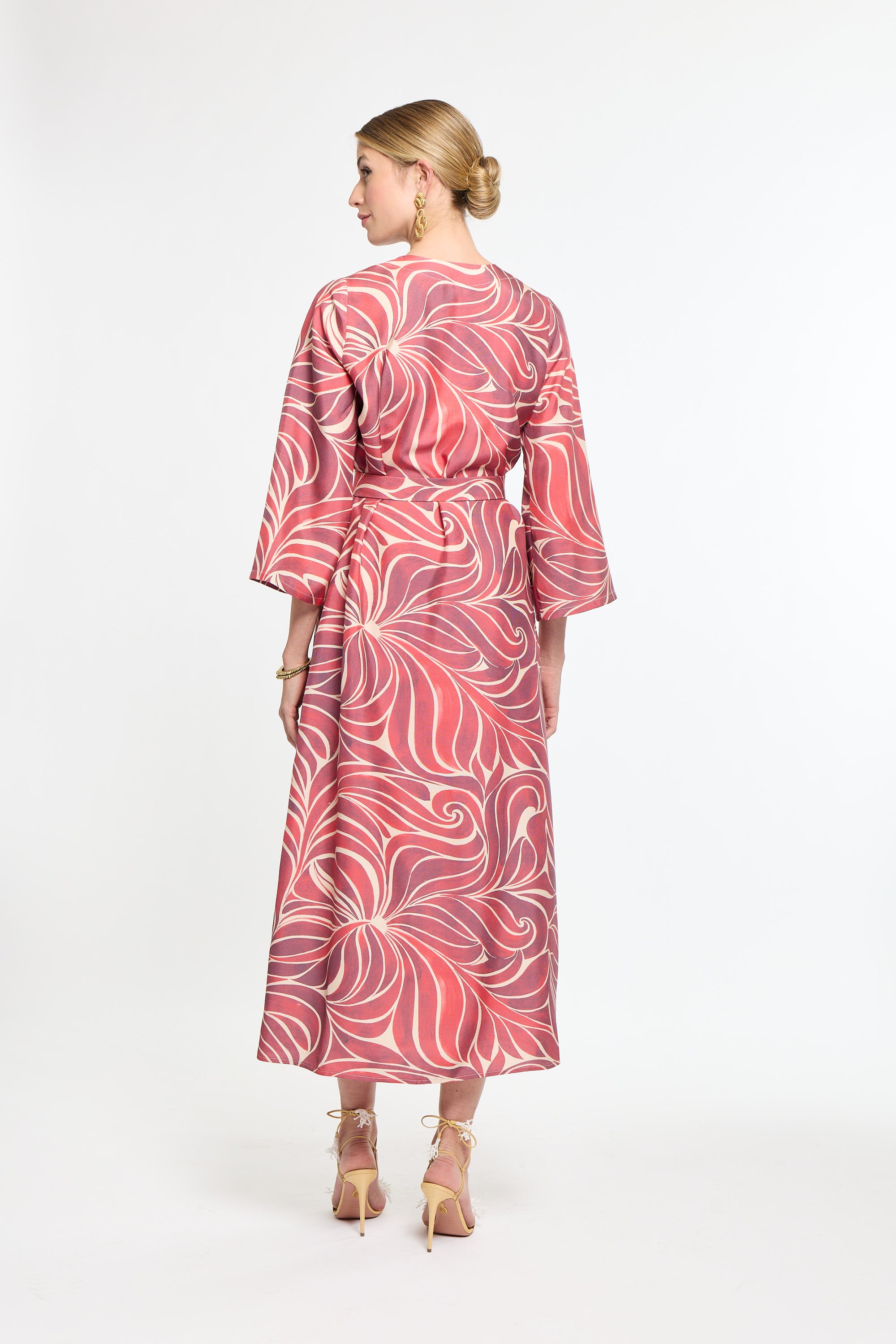 Woman wearing a red and white patterned dress on a white background