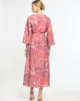 Woman wearing a red and white patterned dress on a white background
