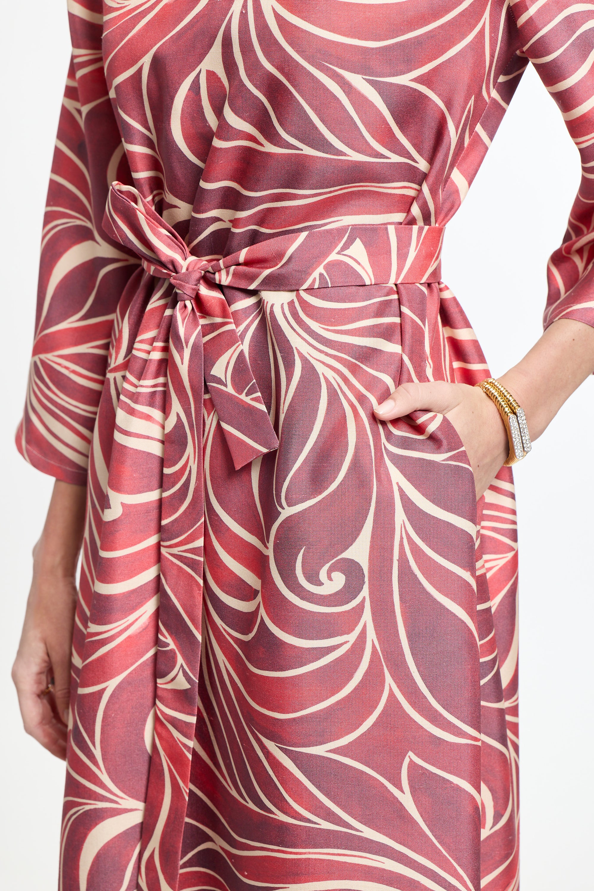 Red and white patterned dress with a belt on a white background