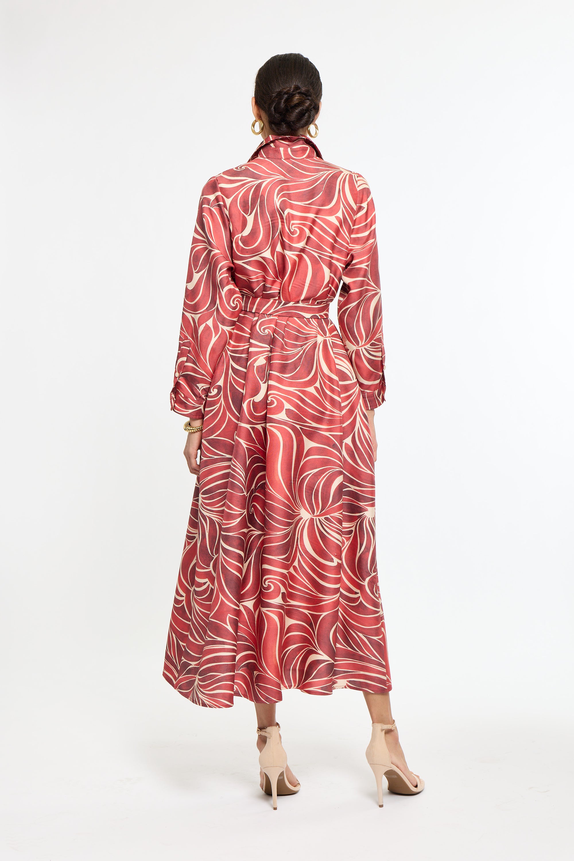 Woman wearing a red and white patterned dress on a white background
