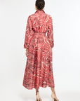 Woman wearing a red and white patterned dress on a white background