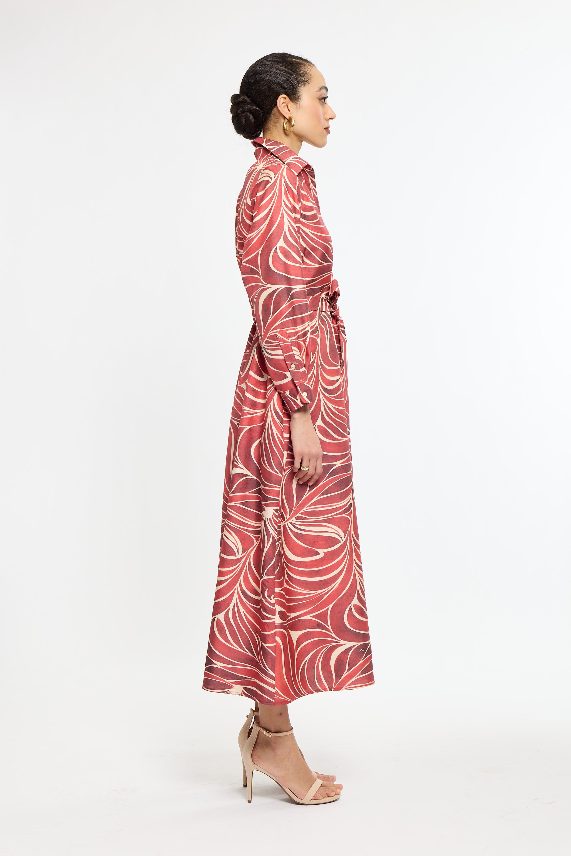 Woman wearing a red patterned dress on a white background