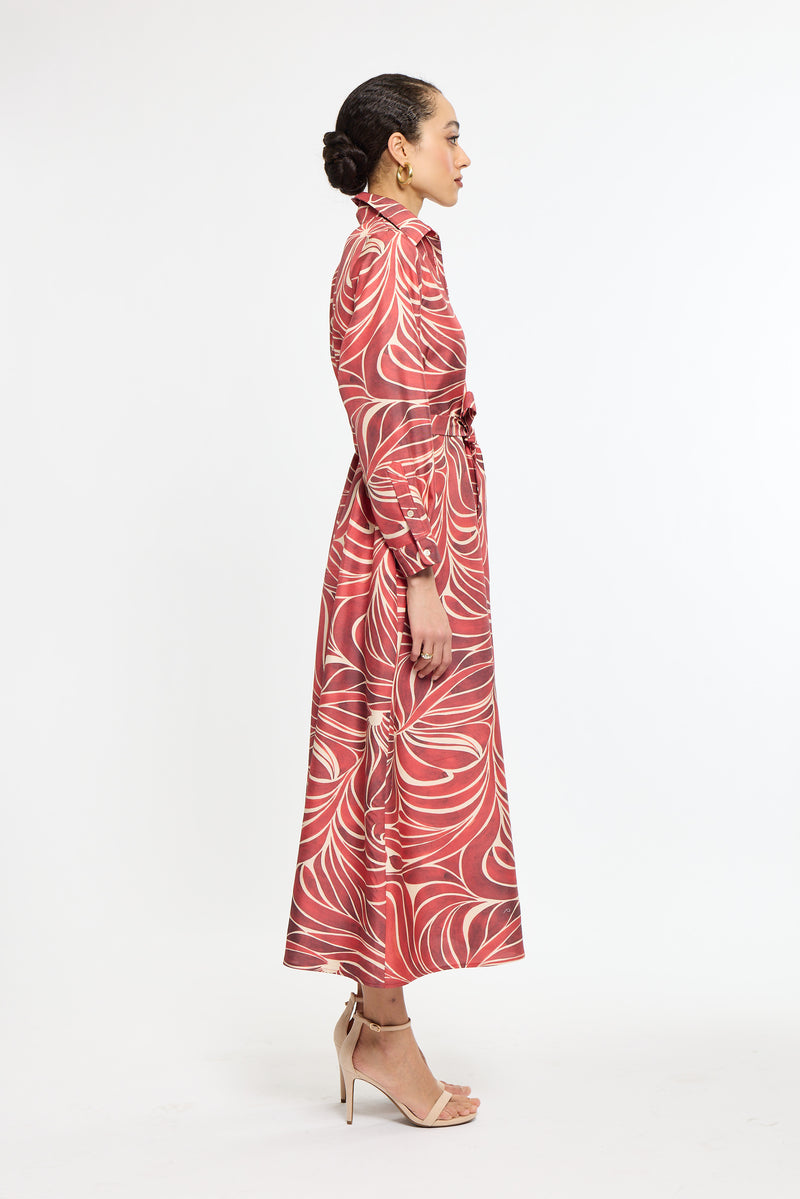 Woman wearing a red patterned dress on a white background