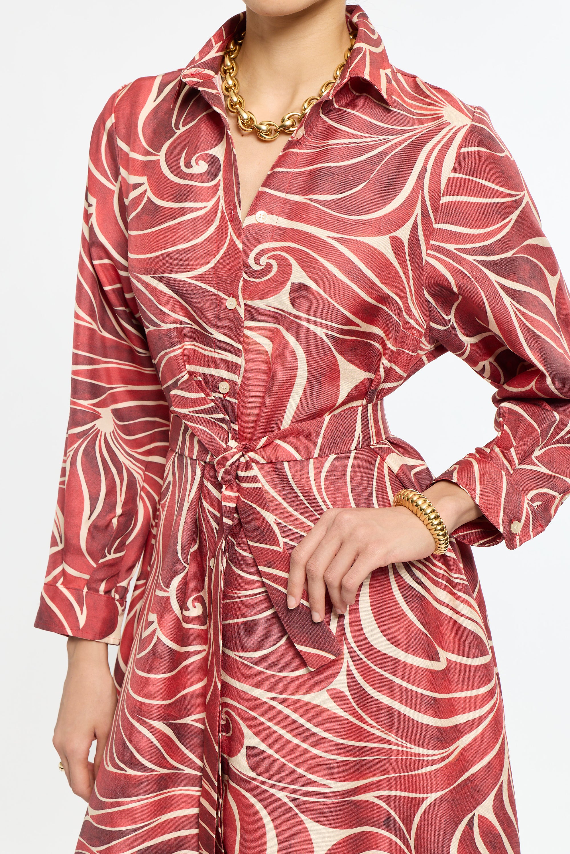 Red and white patterned dress worn by a person on a white background