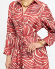 Red and white patterned dress worn by a person on a white background