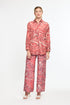 Woman wearing a red and white patterned outfit on a white background