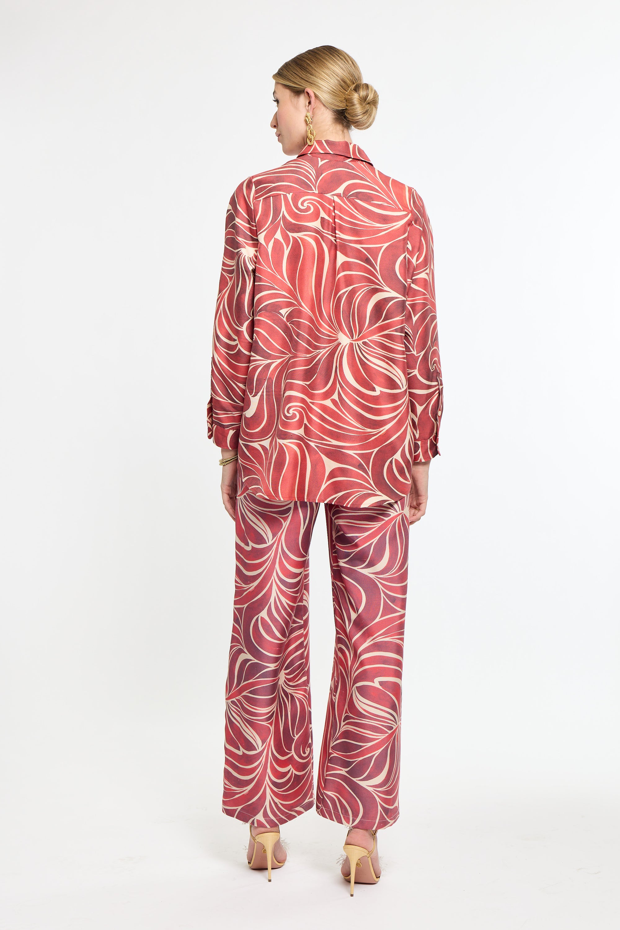Woman wearing a red and white patterned outfit on a white background