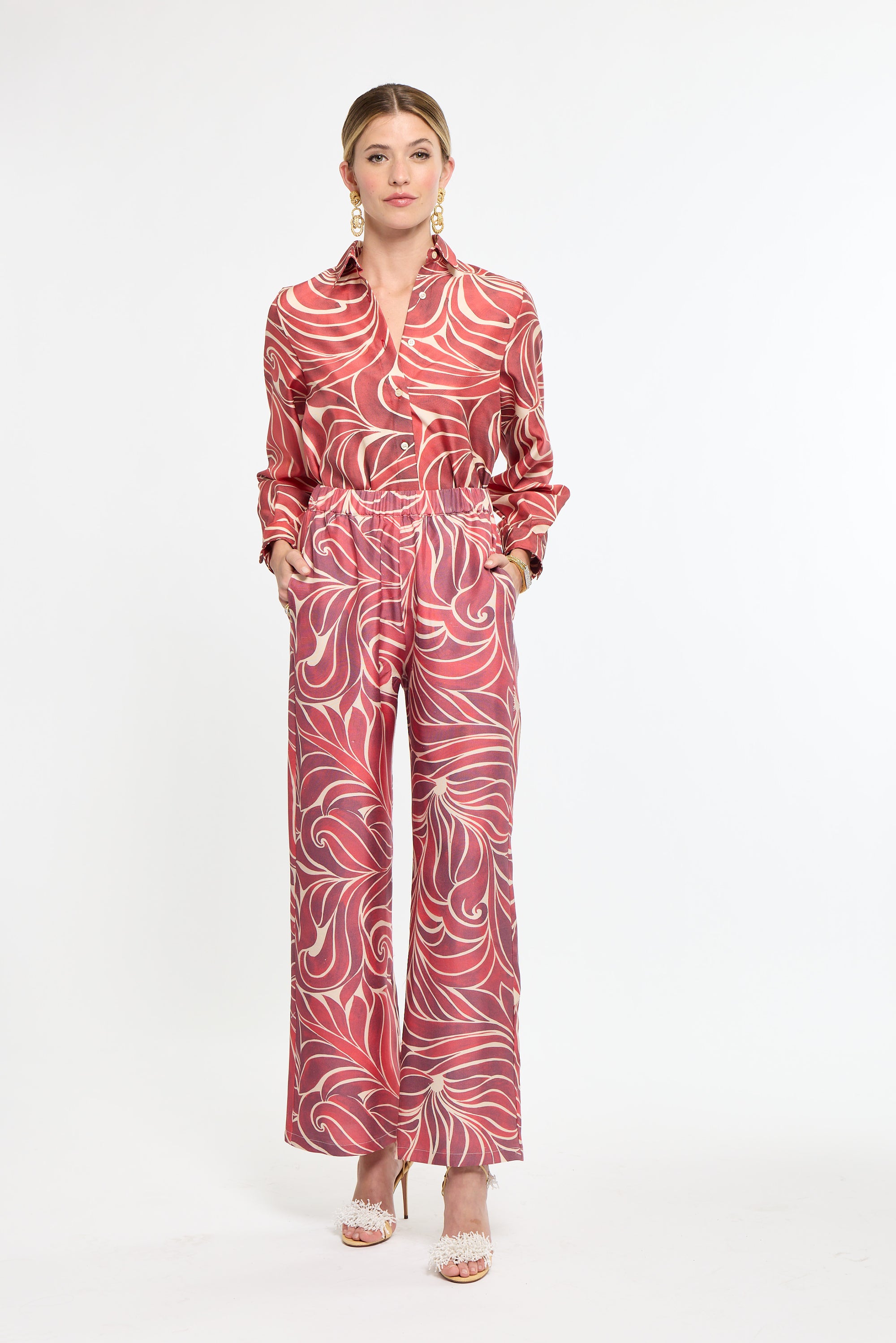 Woman wearing a red patterned outfit on a white background