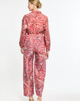 Woman wearing a red and white patterned jumpsuit on a white background